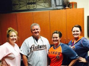 Dentist, Stuart Rimes posing in Astros SWAG with staff
